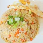 Egg fried rice on a plate with some green onion.