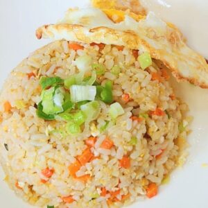 Egg fried rice on a plate with some green onion.