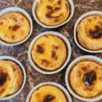 Portuguese egg tart on trays on a marble table.