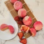 Strawberry snow skin mooncake on a white plate and bamboo tray.