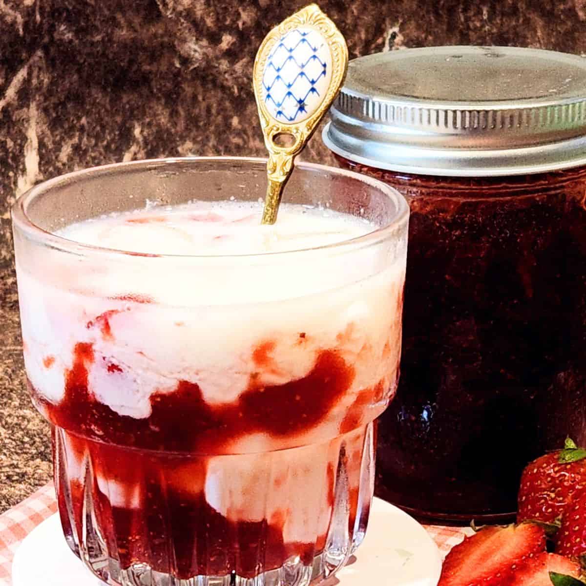 A glass of Korean Strawberry Milk with some fresh strawberries.