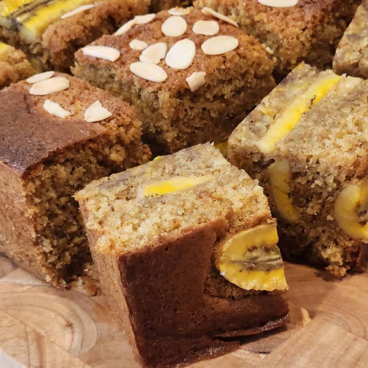 Banana cake cut in squares on a wooden board.