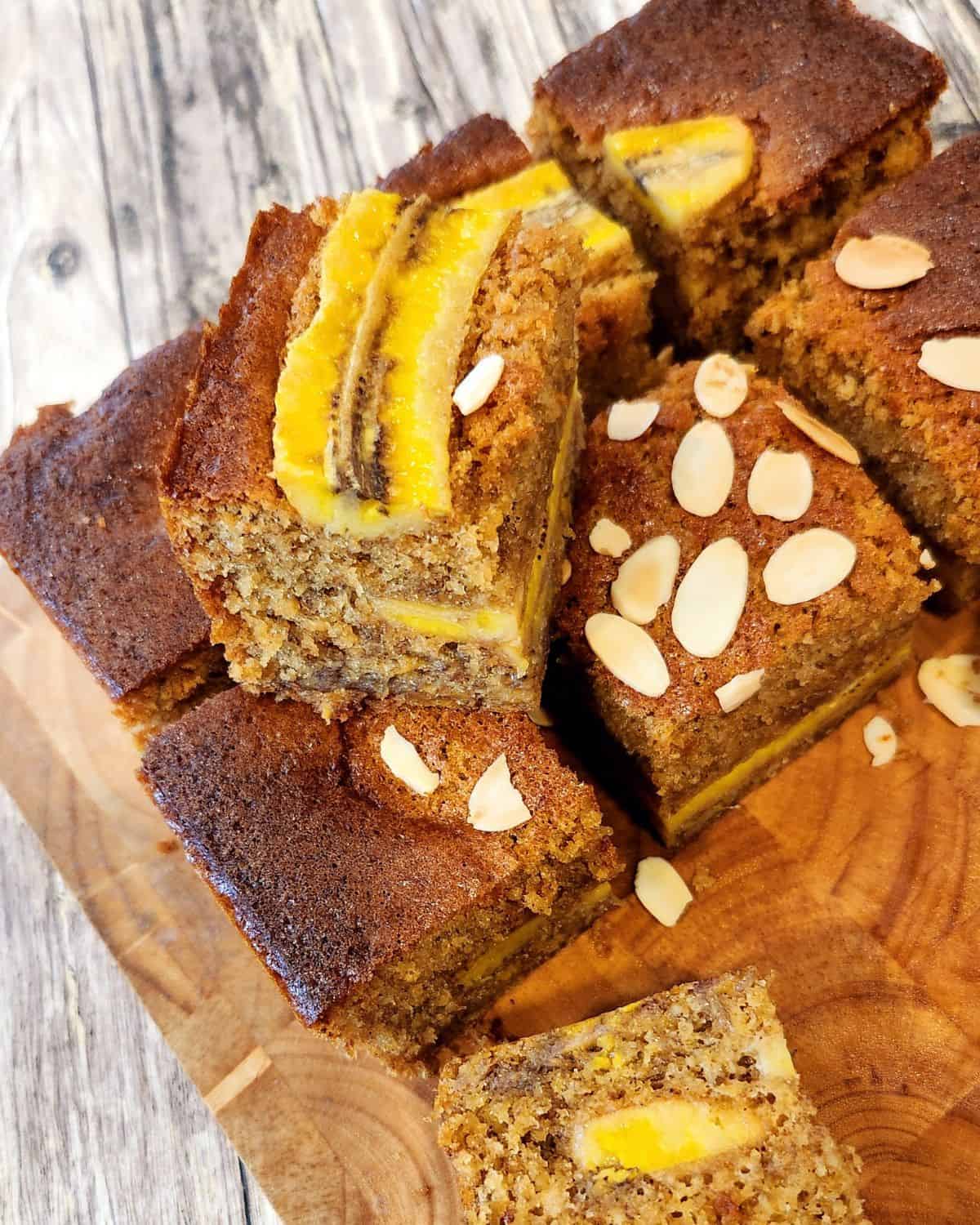 A photo of banana bread sliced in squares on a wooden board.