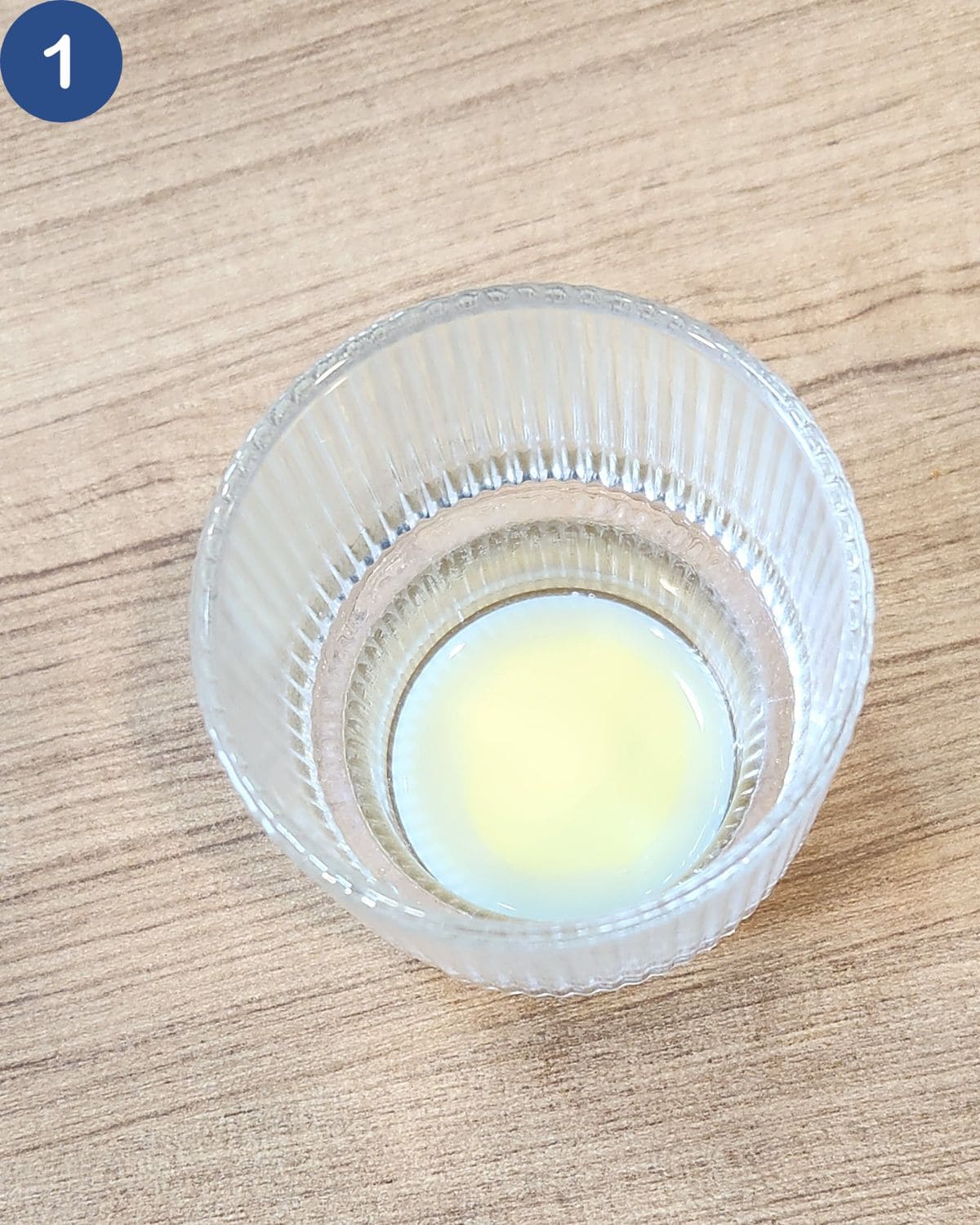 A glass with condensed milk at the bottom. 