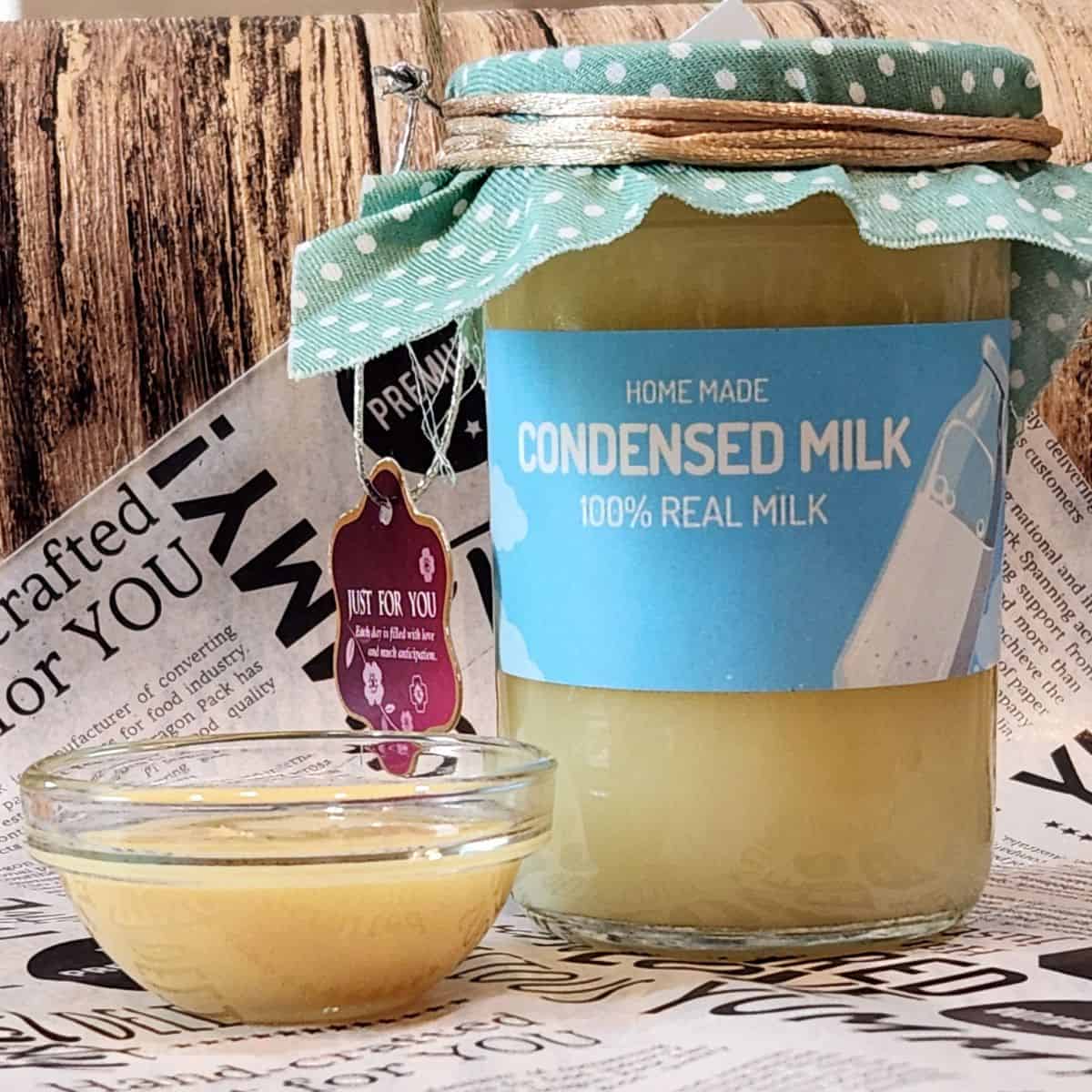 A photo of homemade sweetened condensed milk in a small jar and a small cup.