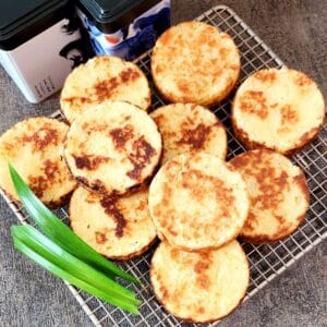 A few pieces of Wingko Babat on a cooling tray with pandan leaves.