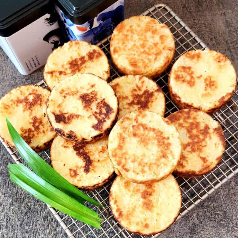 A few pieces of Wingko Babat on a cooling tray with pandan leaves.