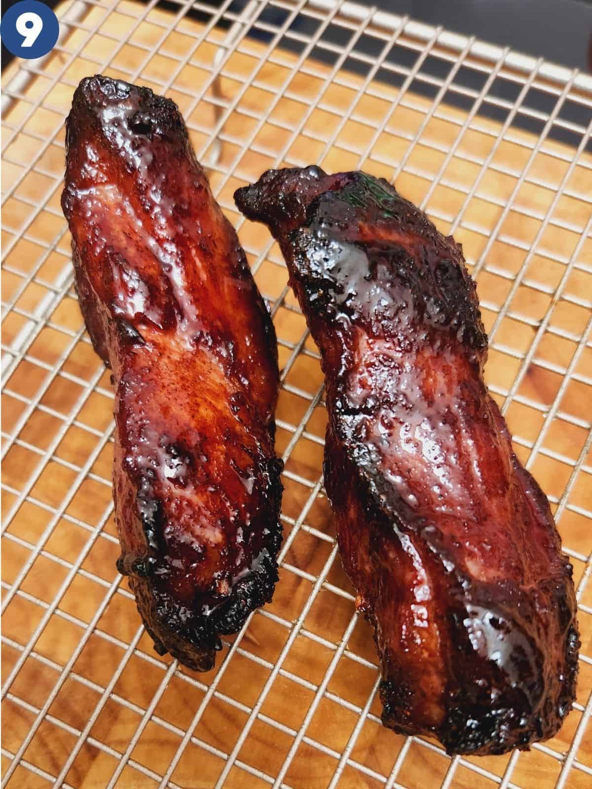 Two big chunks of char siu roasted pork on a cooling rack.