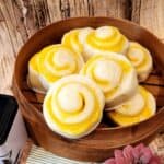 Chinese steamed bun with Cheese filling piled on a bamboo steamer.