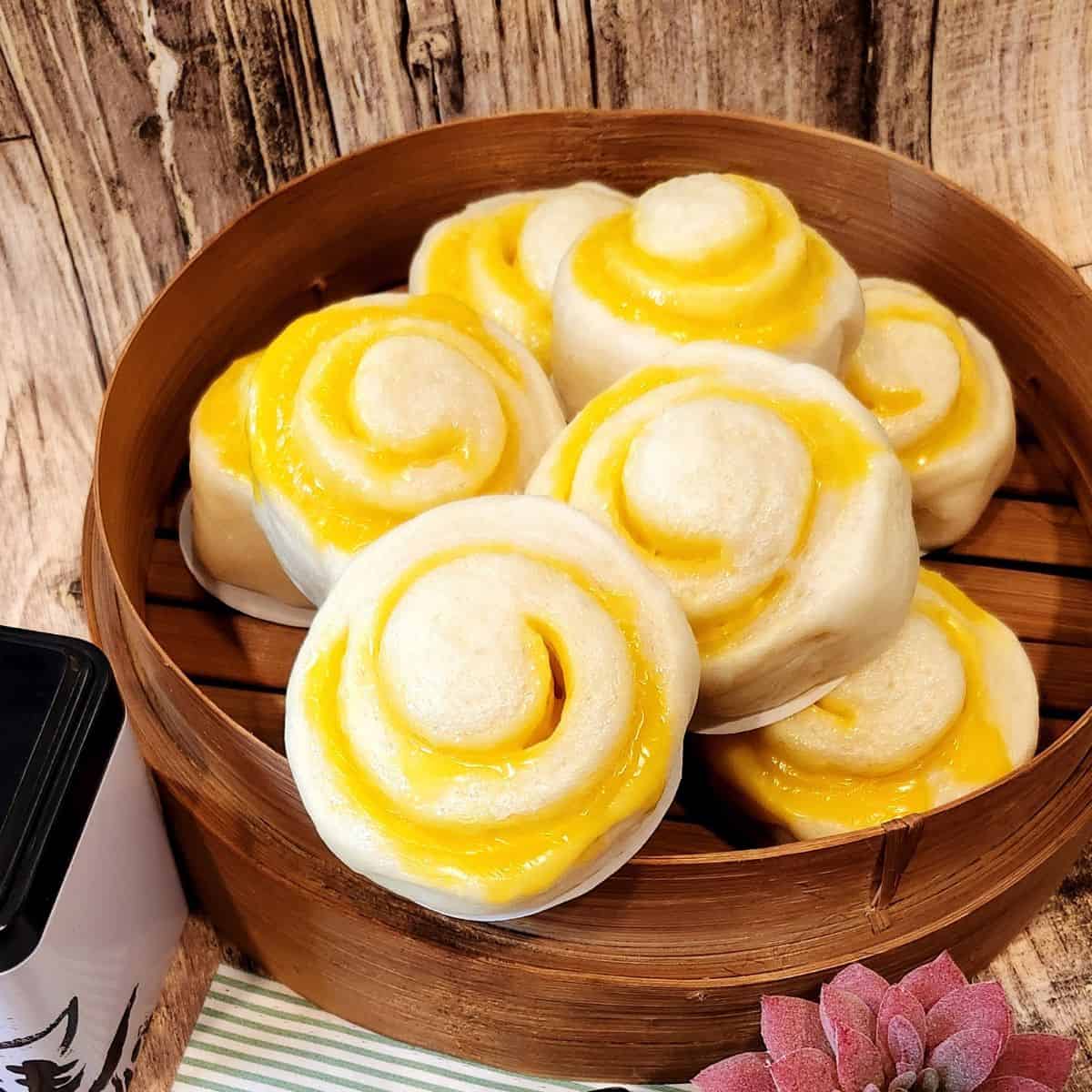 Chinese steamed bun with Cheese filling piled on a bamboo steamer.