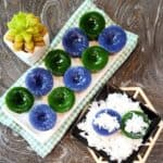 Kuih Kosui pandan and butterfly pea flower on a white rectangular plate with some grated coconut.