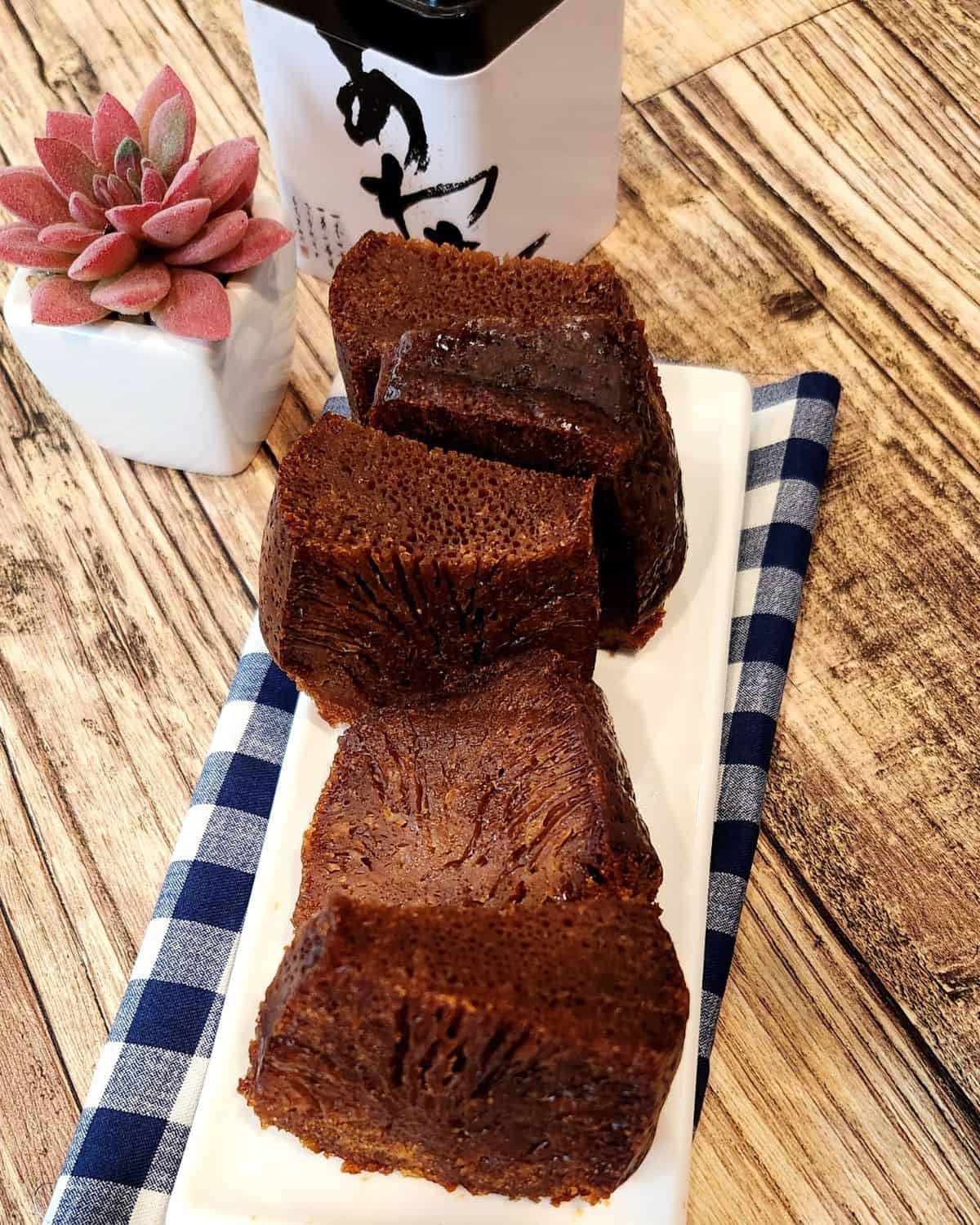 Malaysian honeycomb cake slices or kek sarang semut on a white, rectangular plate on a wooden table. 