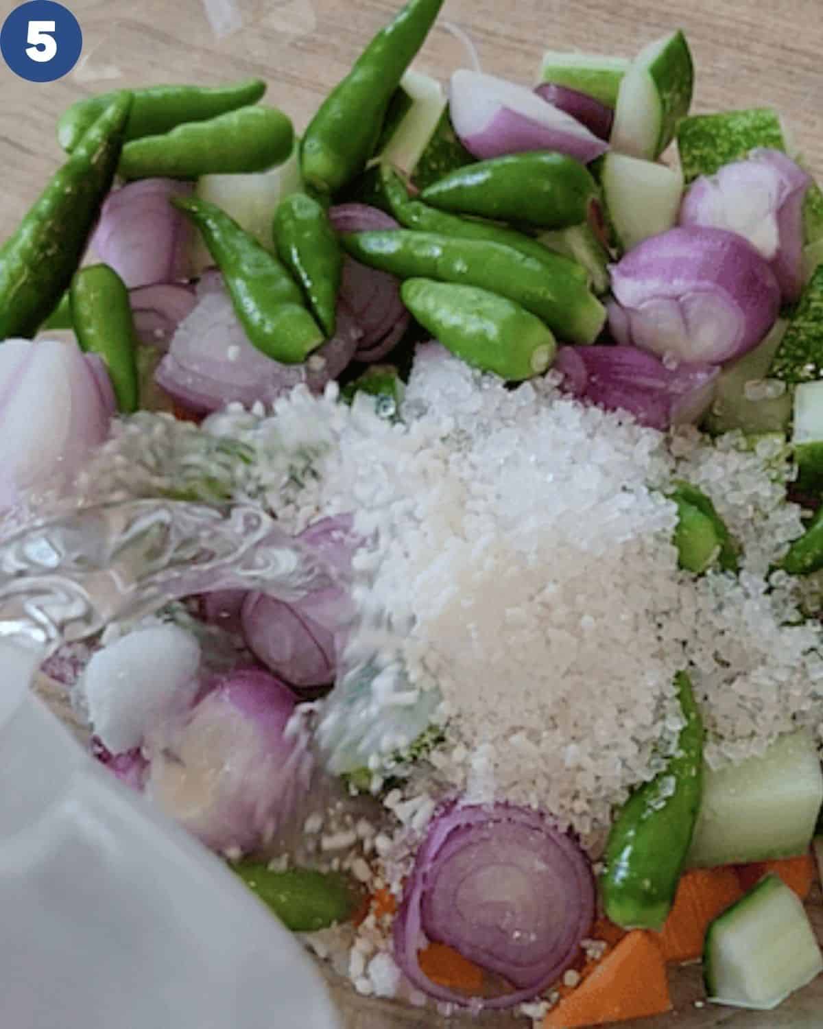Acar timun ingredients with water pouring in.
