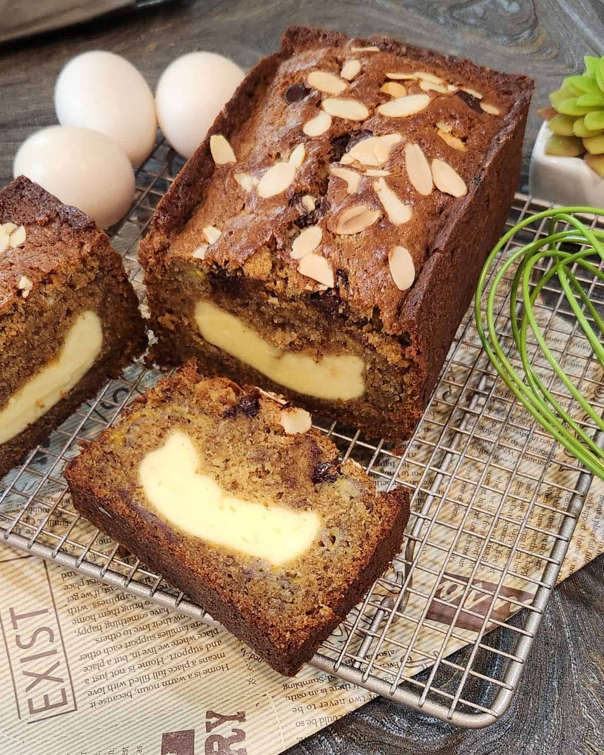Banana pound cake with cream cheese on a cooling rack.