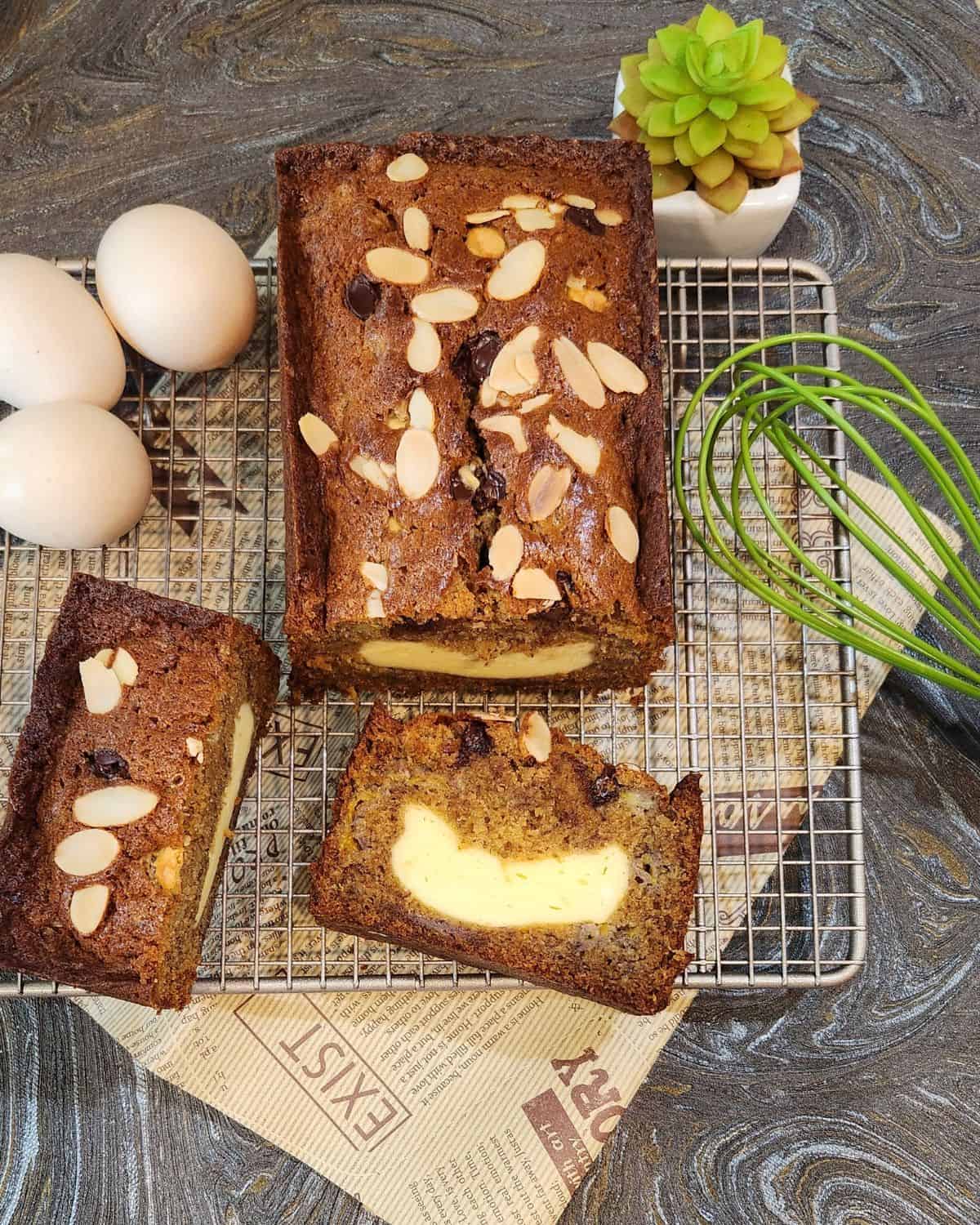 Banana pound cake with cream cheese on a cooling rack.
