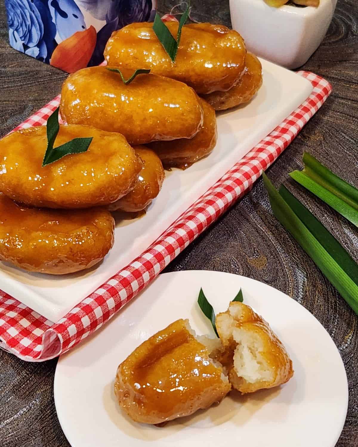 A small plate of gemblong ripped open with other gemblong at the back.