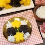 A golden plate of getuk lindri with grated coconut.