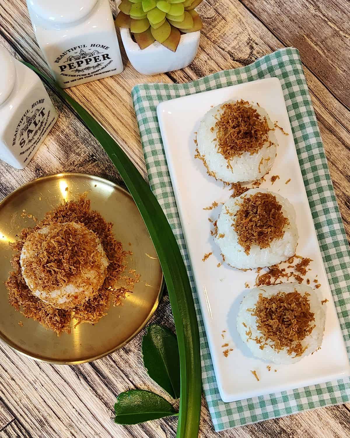 A plate of ketan serundeng with lime leaves and pandan leaves decoration.