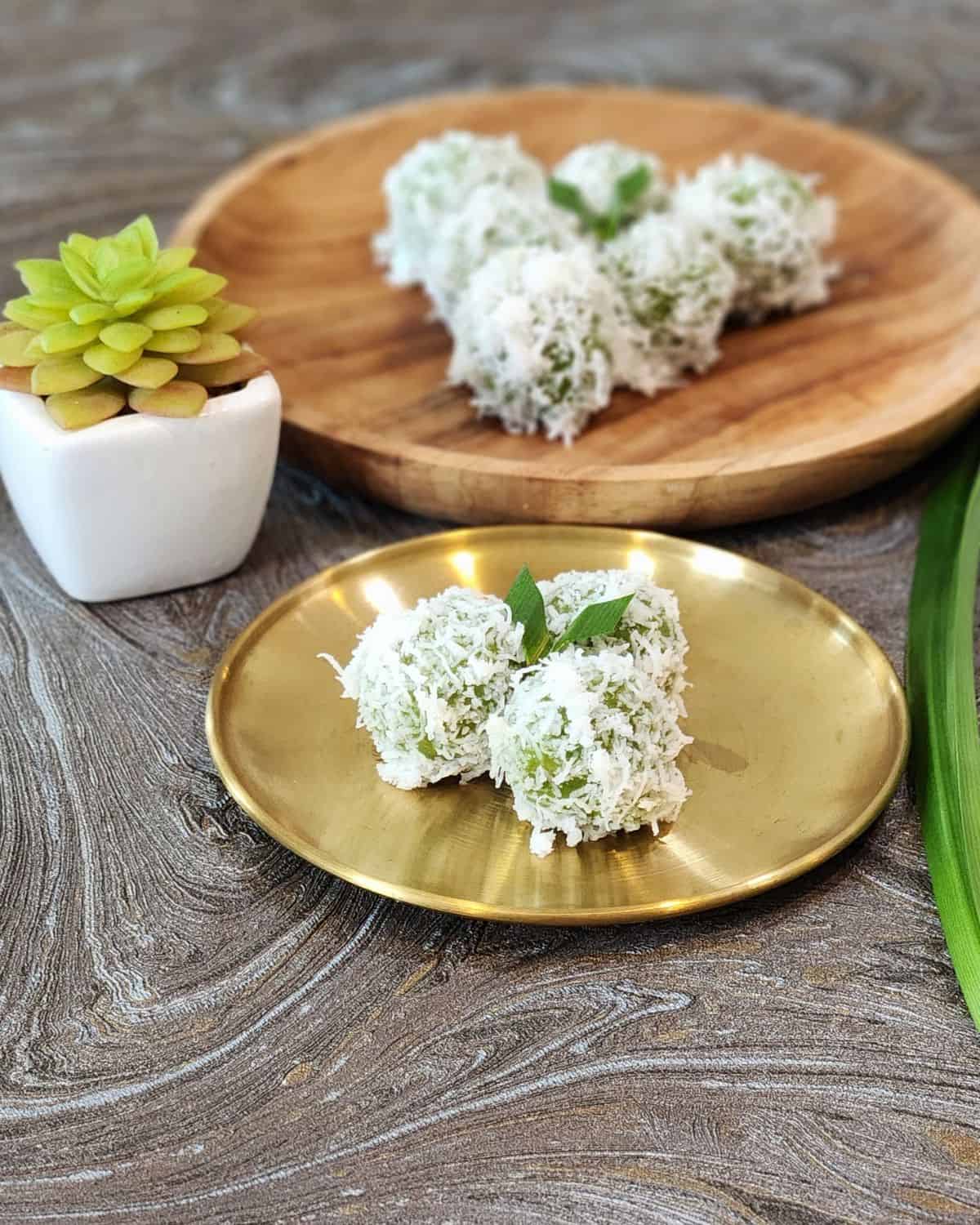 A small golden plate of three klepons or onde onde.