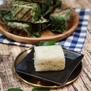 A small black plate with lemper ayam.
