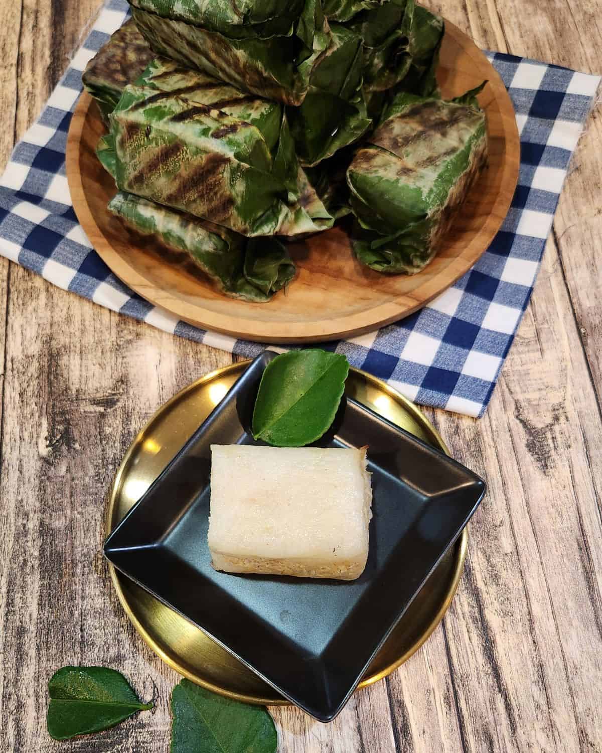 A small black plate with lemper ayam.