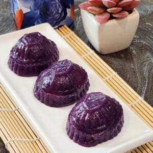 A plate of three angku kueh made of purple sweet potato.