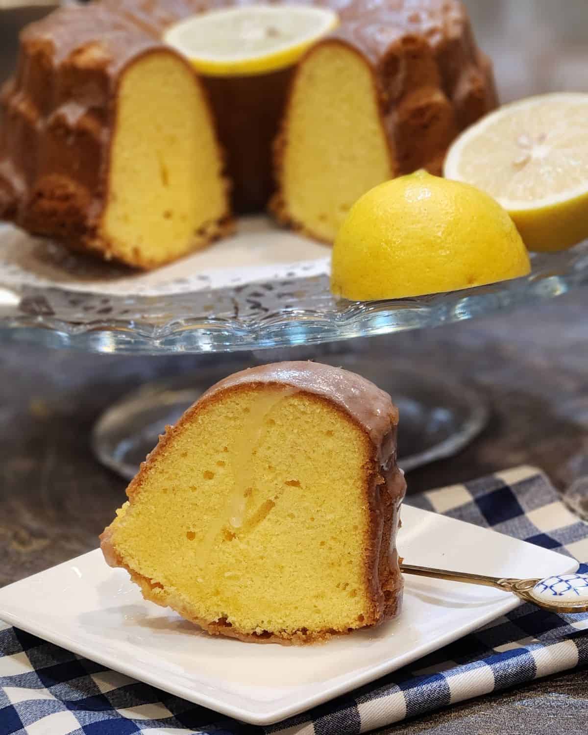 A slice of lemon butter cake in front of a big pan of cake.