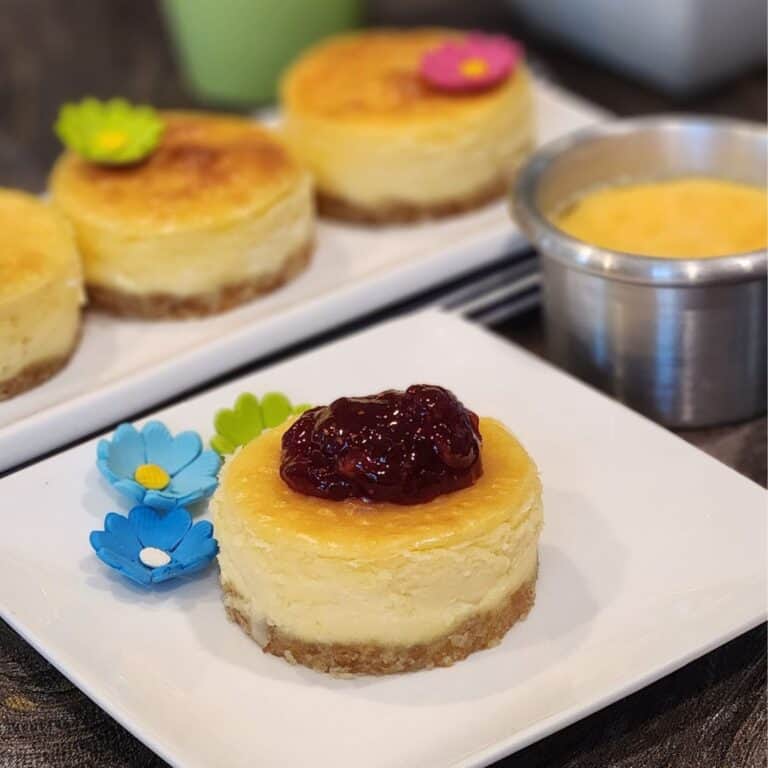 A plate of mini New York cheese cake with strawberry jam.