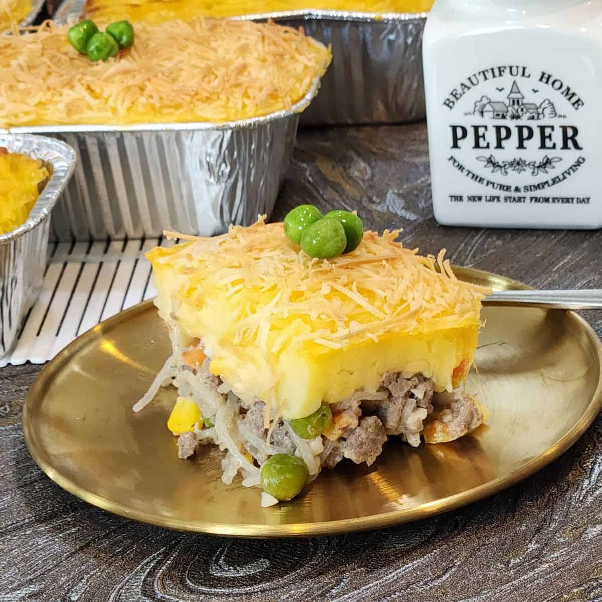 A slice of pastel tutup on a golden plate.