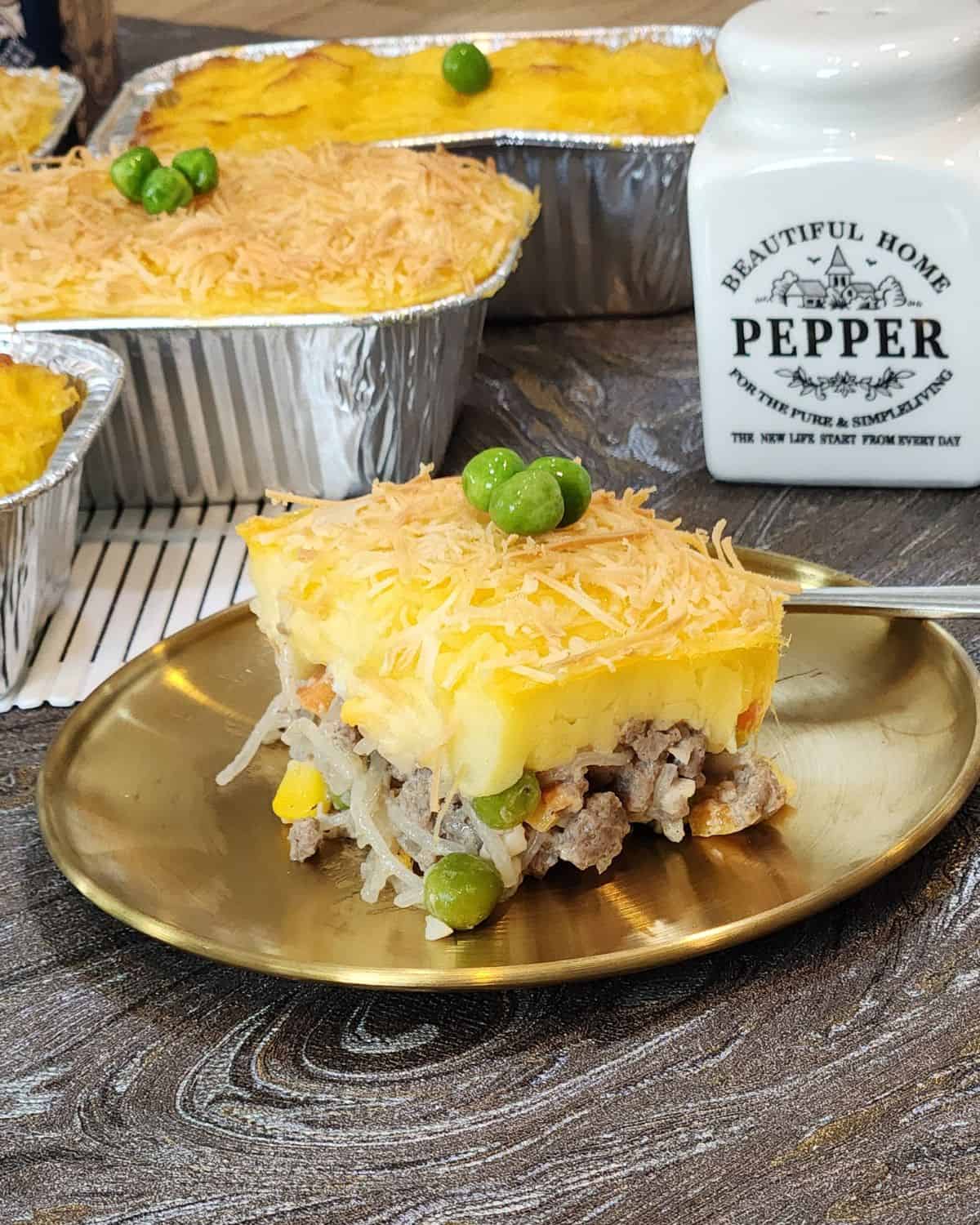 A plate of Pastel tutup slice with green peas on top.