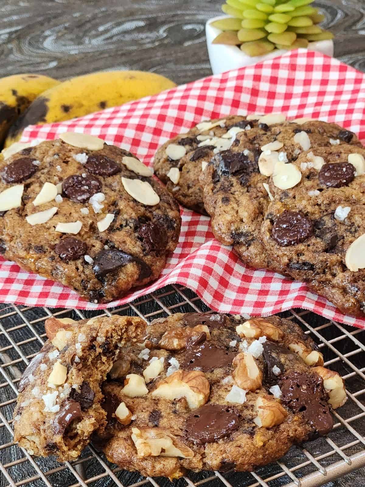 Several banana almond soft cookies on a cooling rack with red white cloth.