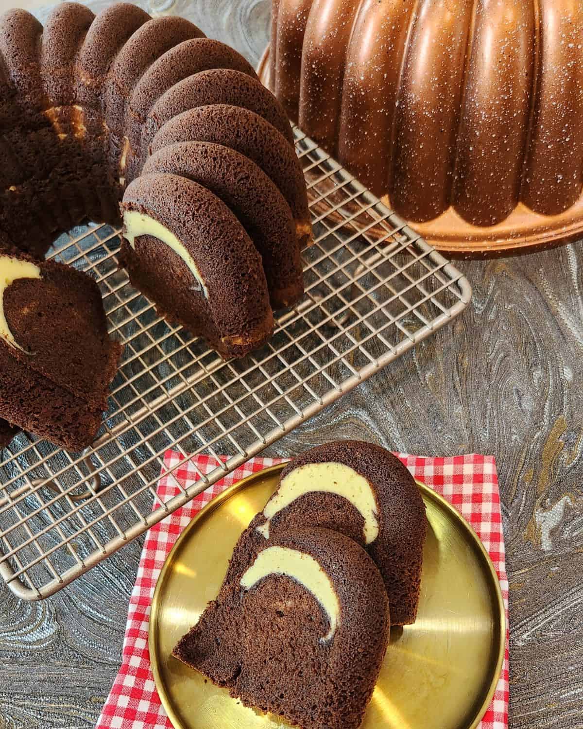 Two slices of chocolate cake with cream cheese filling on a golden plate.
