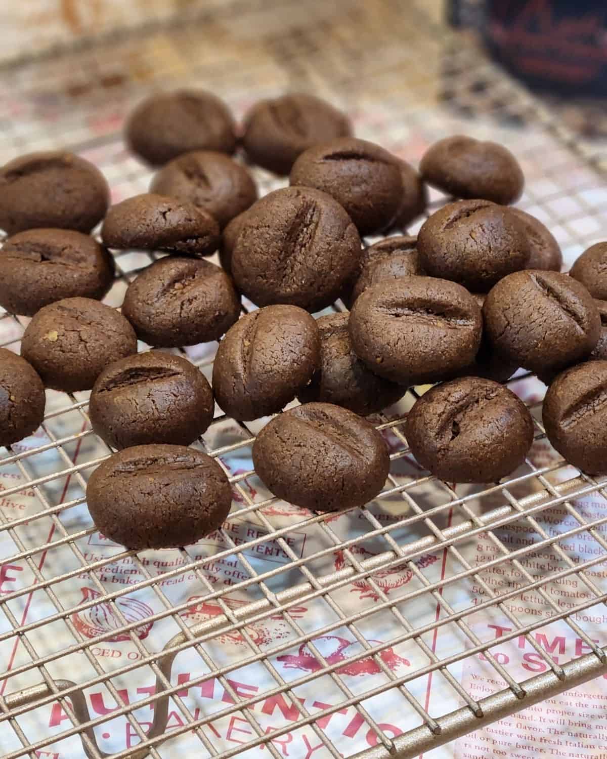 Several coffee bean cookies spread on a wire rack.