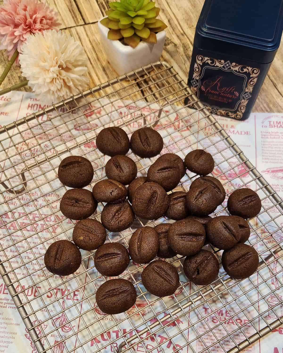 Several coffee bean cookies spread on a wire rack.