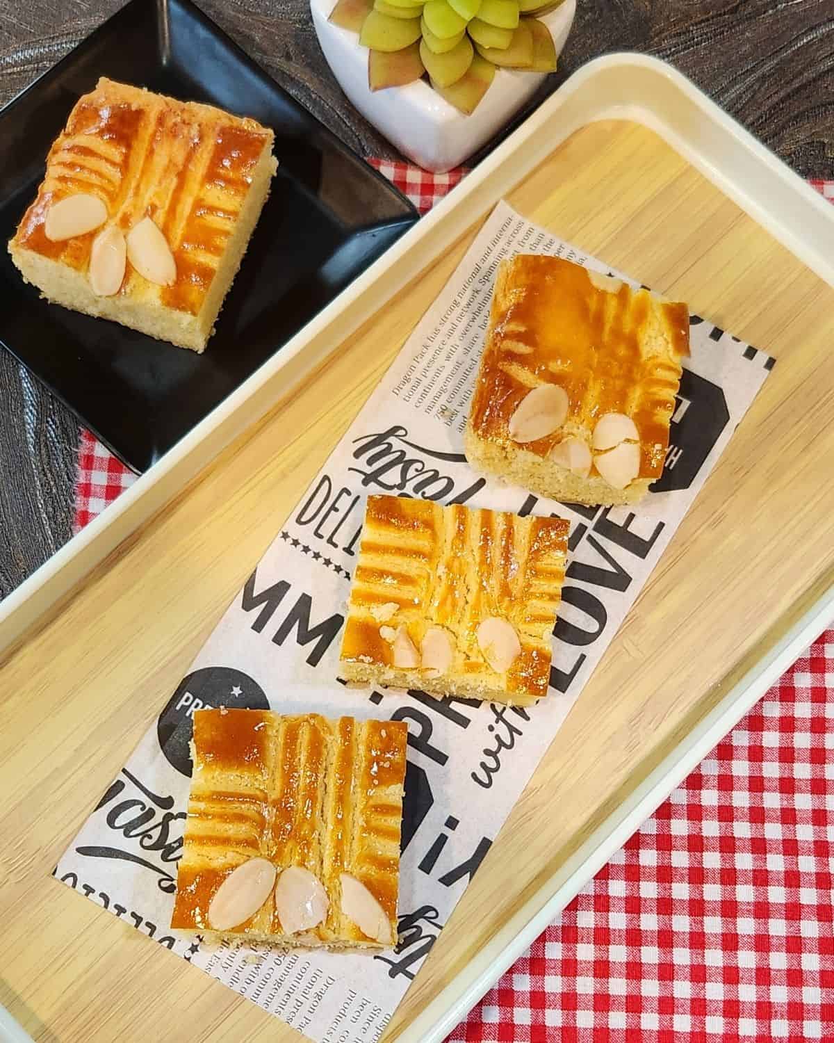 A few slices of Dutch Butter Cake on a tray and a black plate.