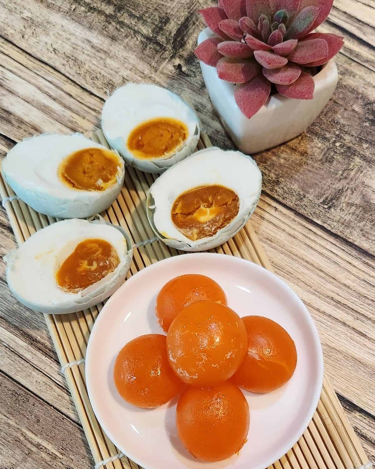 A stack of salted egg yolks and a few of cooked salted eggs.