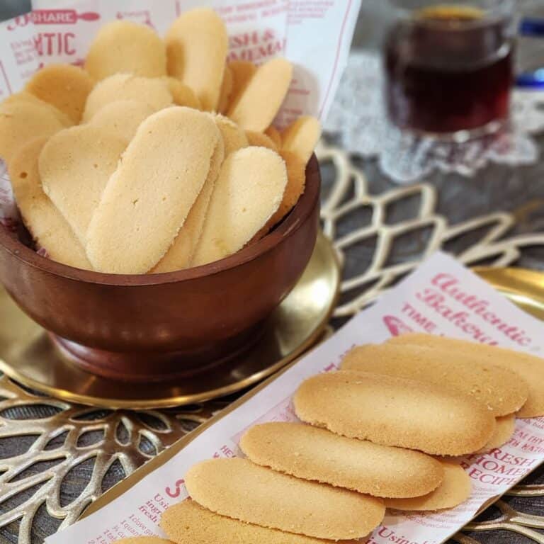 A bunch of cat tongue cookies on a plate and a bowl.