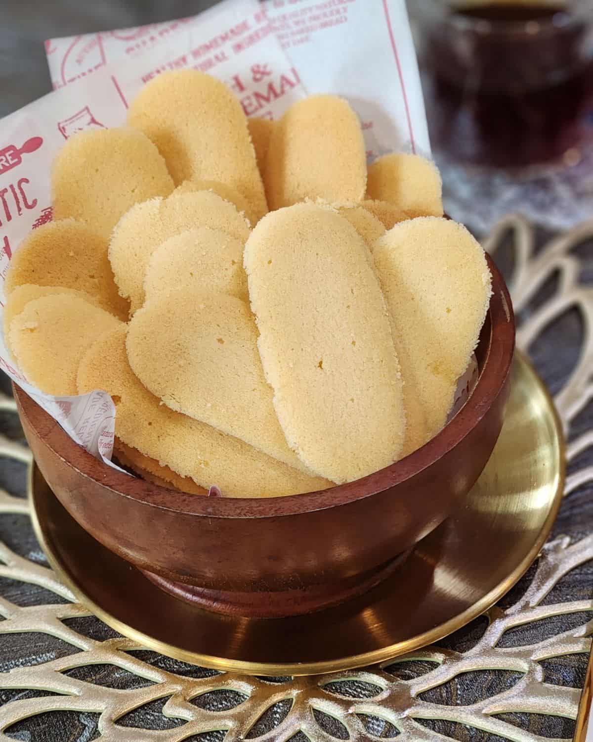 A bunch of cat tongue cookies in a bowl.