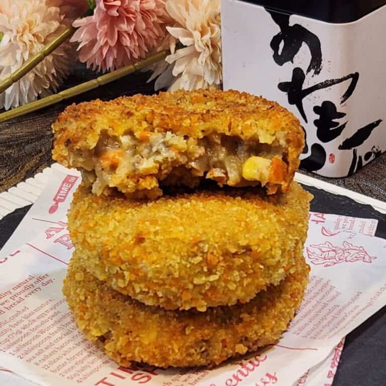 A stack of Japanese croquettes with one that is already sliced.