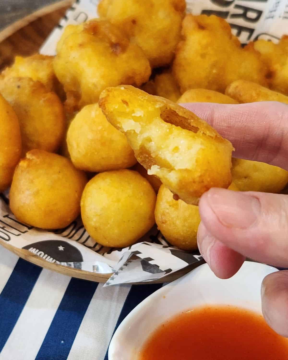 A hand holding perkedel Fried Mashed Potato Patties.
