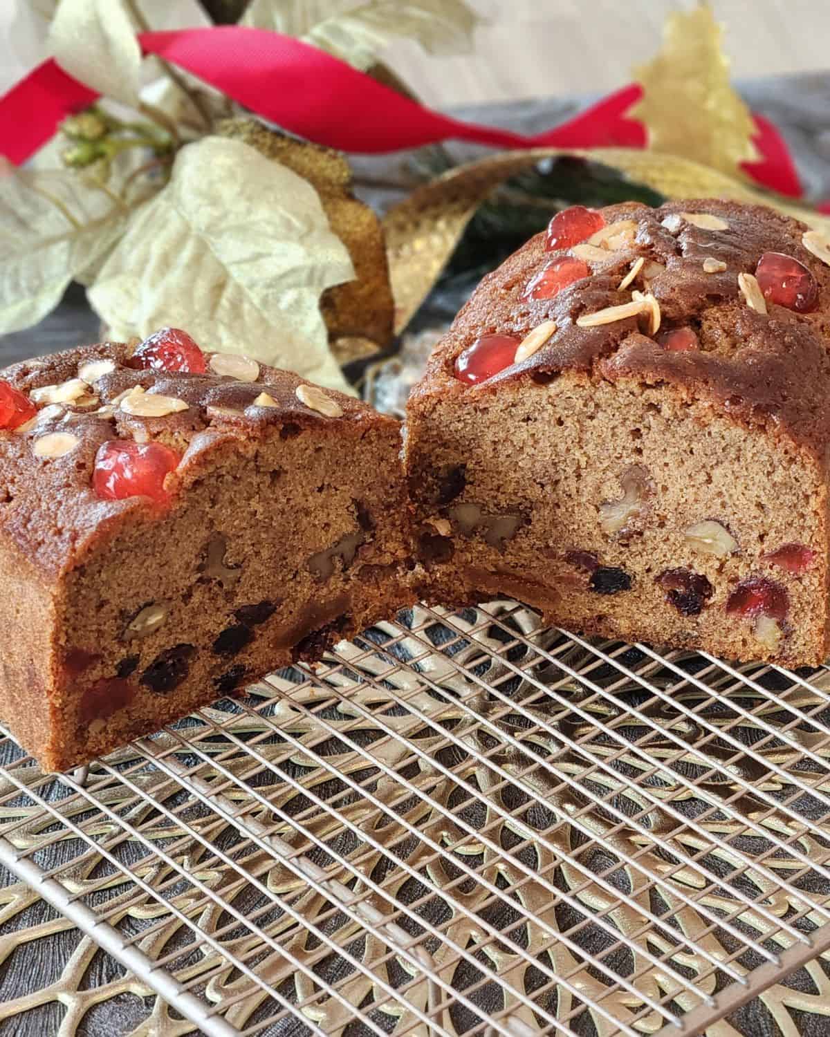 English fruit cake sliced in two revealing the fruits inside.