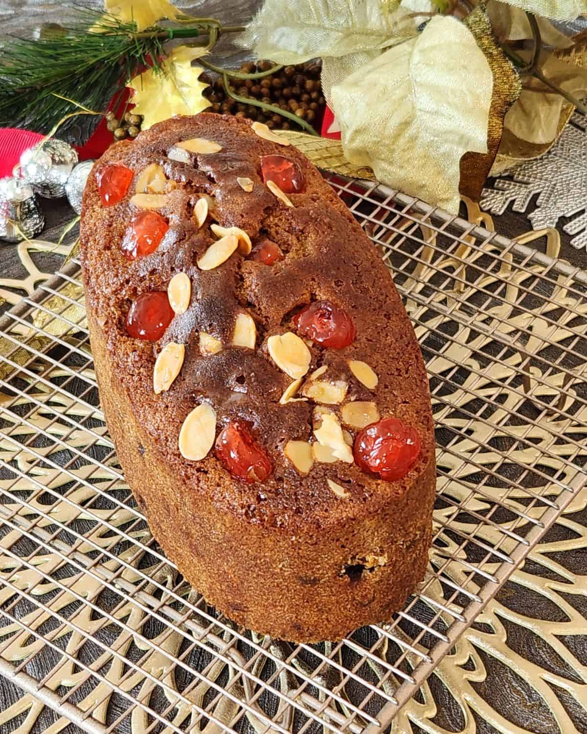 A loaf of English fruit cake on a wire rack.