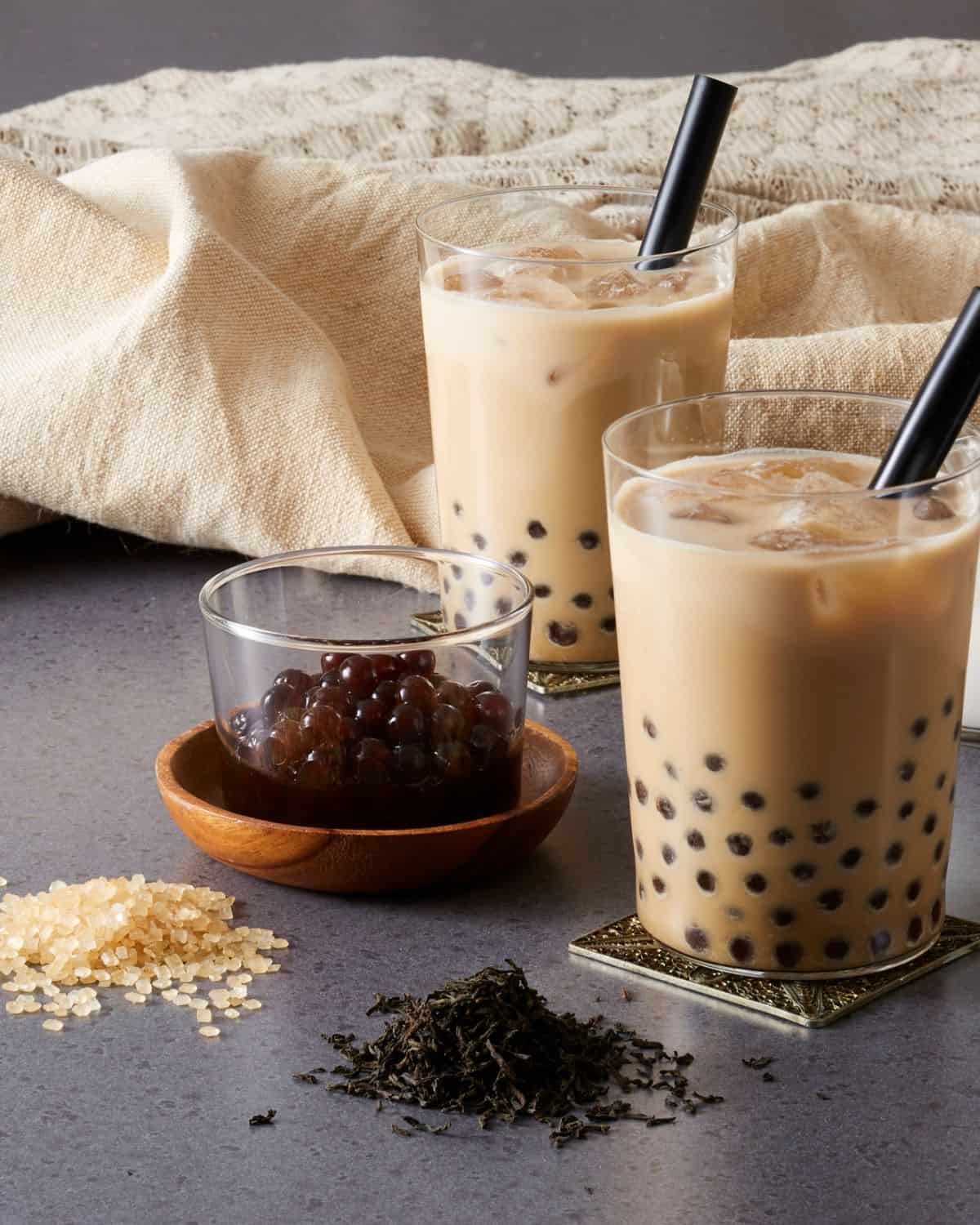 A cup of cooked tapioca pearls with a pair of milk tea bobas.