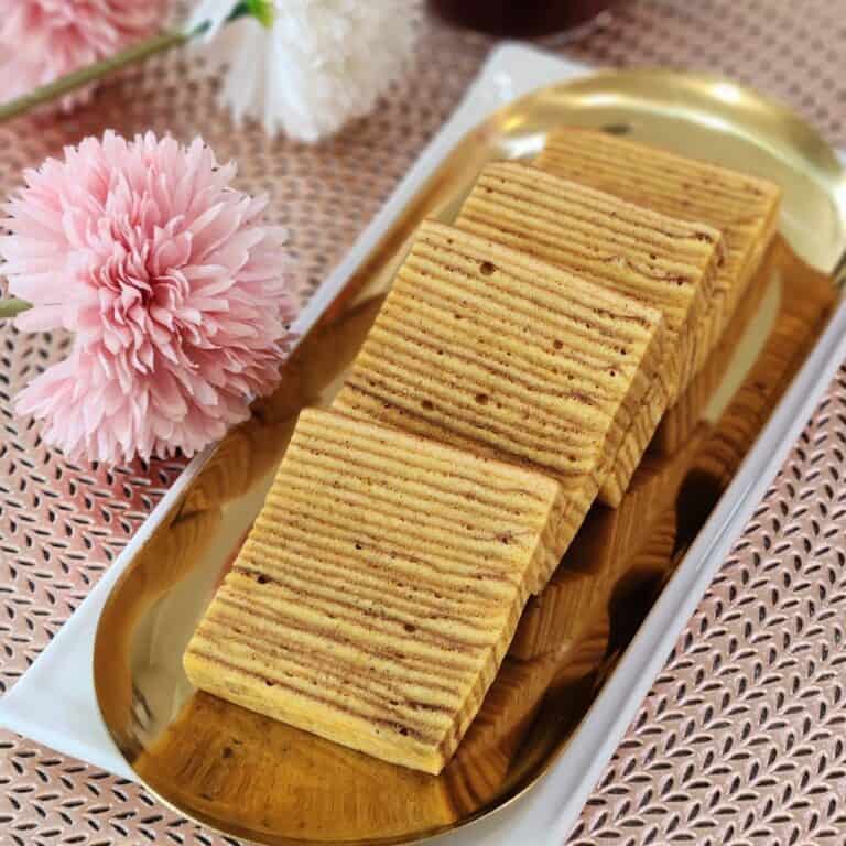 A few slices of Lapis Legit Spekkoek on a golden plate.