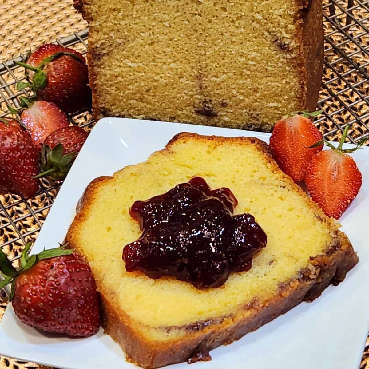 A slice of strawberry cream cheese pound cake with more strawberry jam on top.