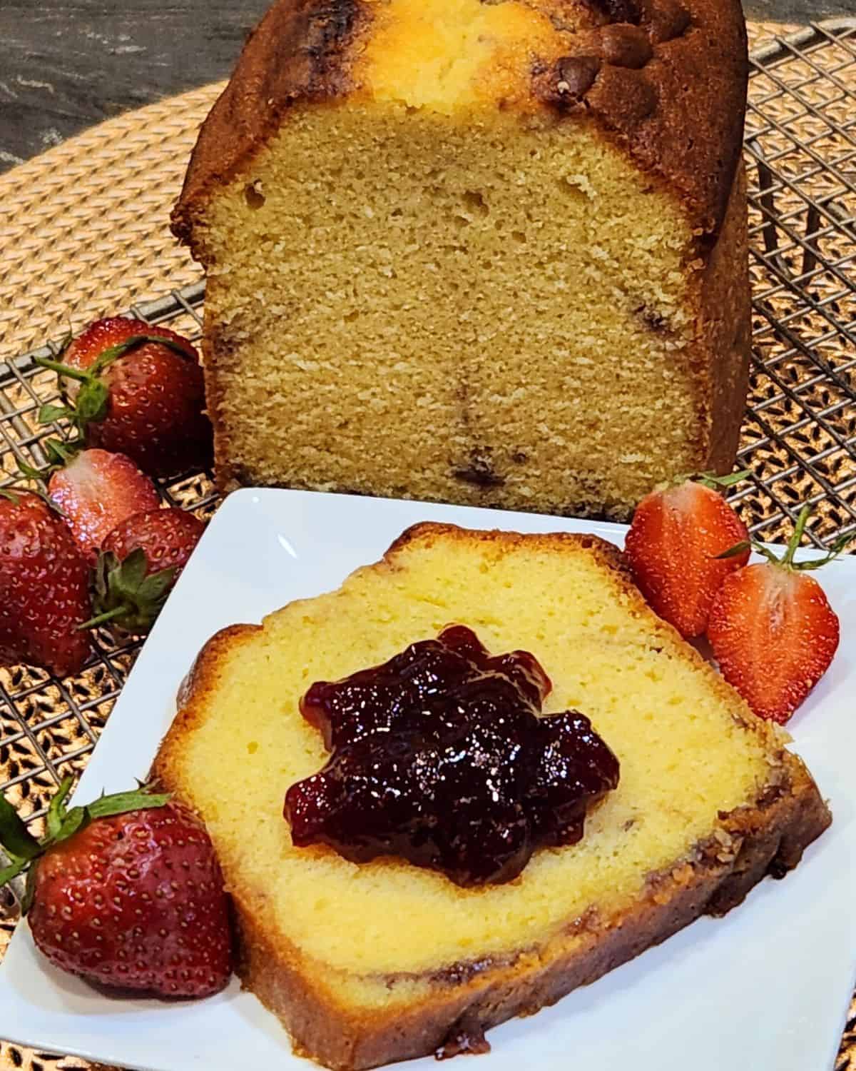 A slice of strawberry cream cheese pound cake with more strawberry jam on top.