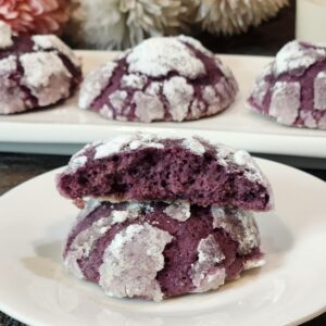 A stack of Ube Crinkle Cookies on a white plate.