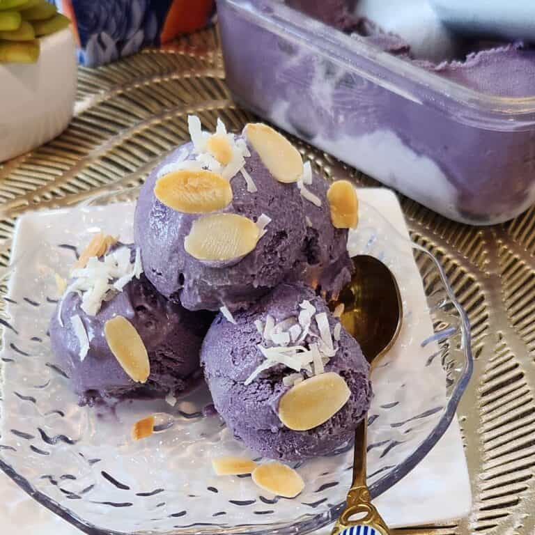 Homemade ube ice cream sprinkled with coconut and almond slices.