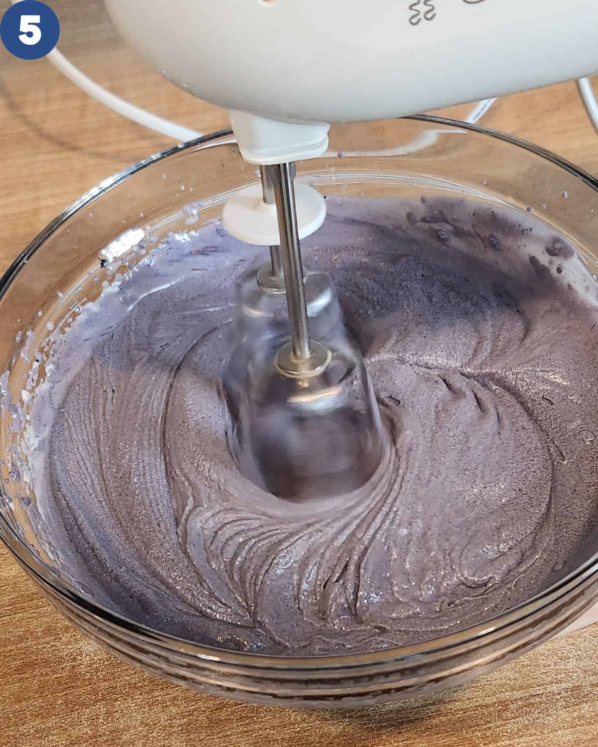 A photo of mixing the ube ice cream until incorporated.