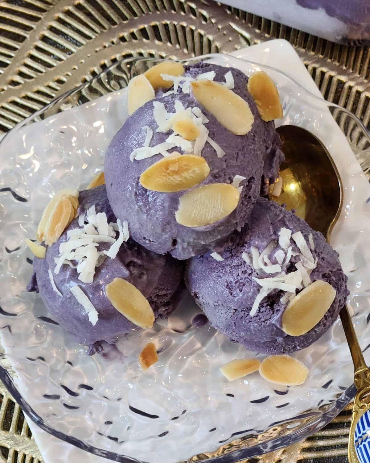 Homemade ube ice cream sprinkled with coconut and almond slices.